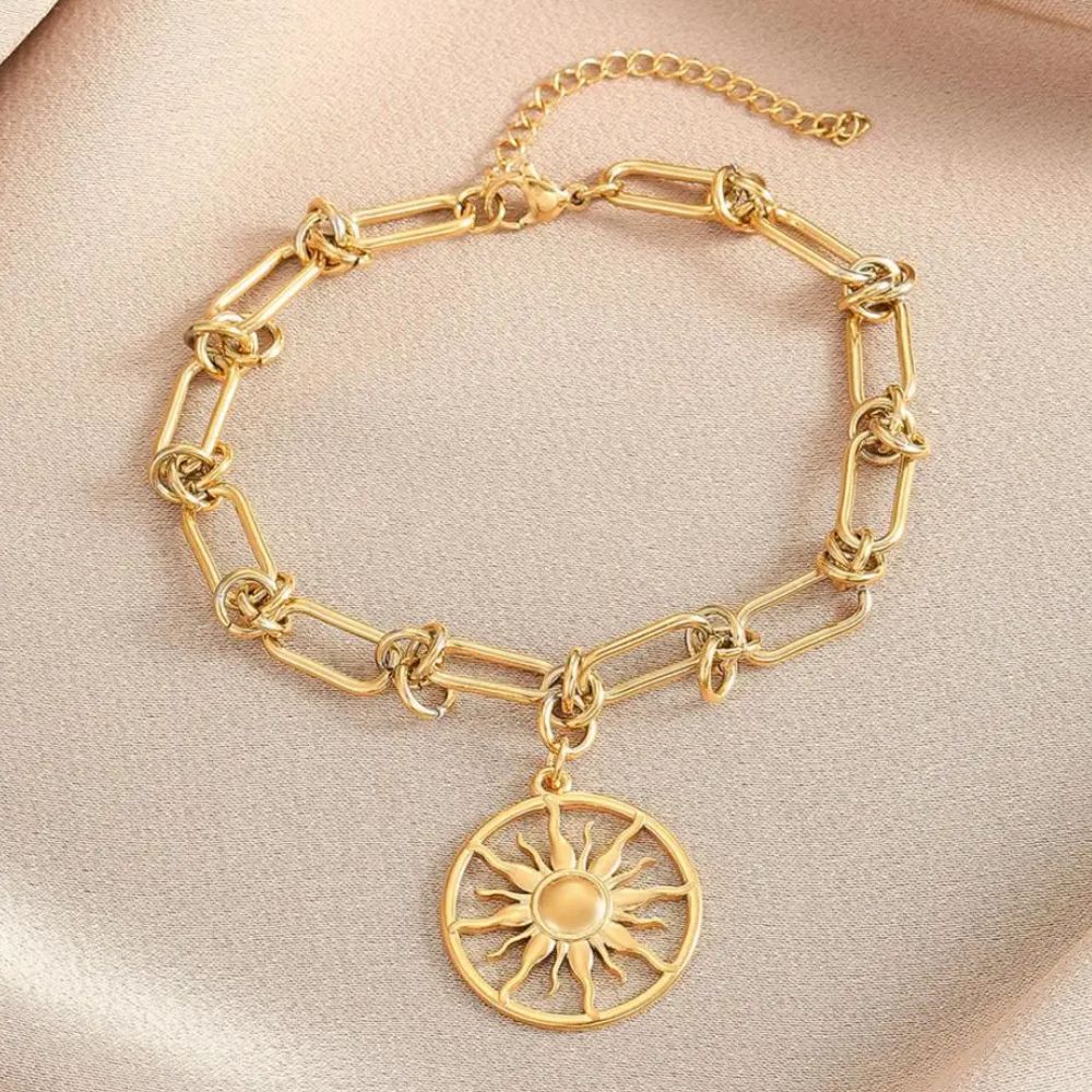 bracelet avec un pendentif circulaire et un symbole du soleil